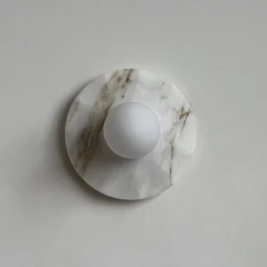 Modern round marble wall sconce with circular marble plate and spherical frosted glass shade