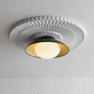 Contemporary black ceiling light fixture installed with vintage carved white medallion detail