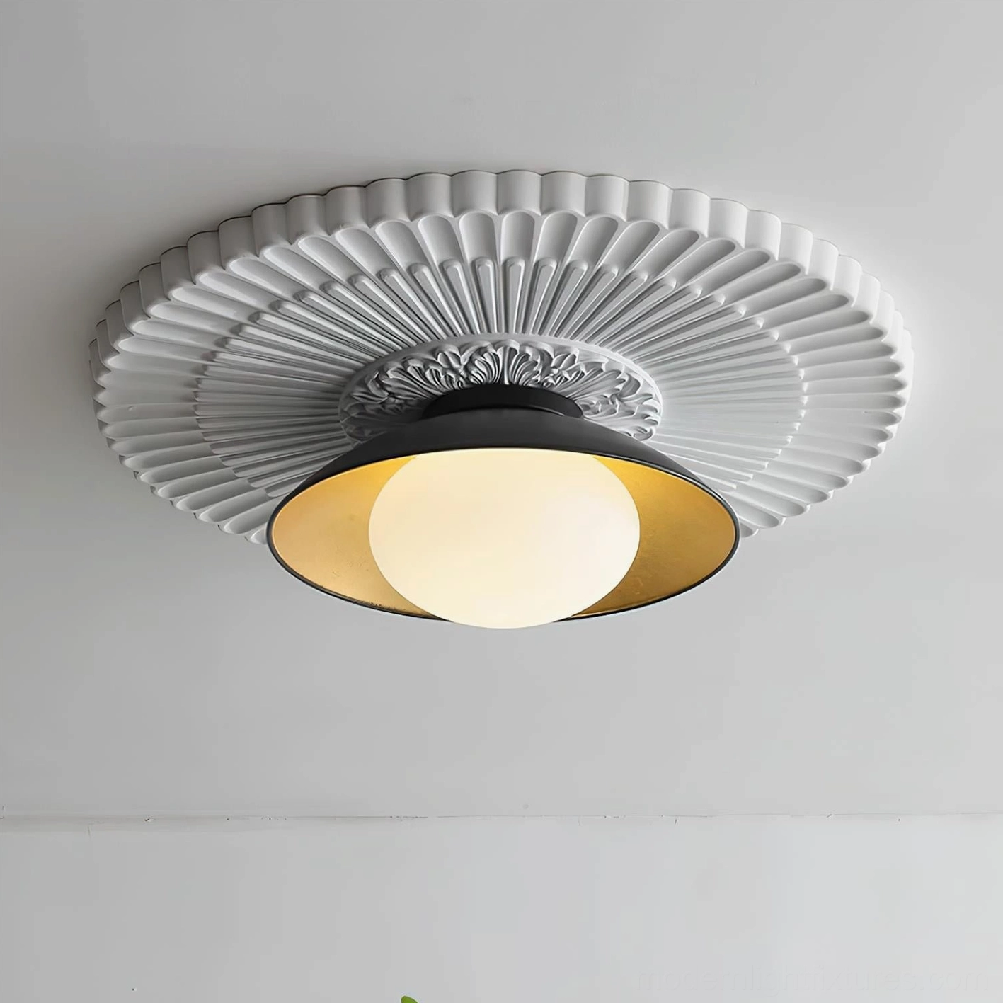 Contemporary black ceiling light fixture installed with vintage carved white medallion detail