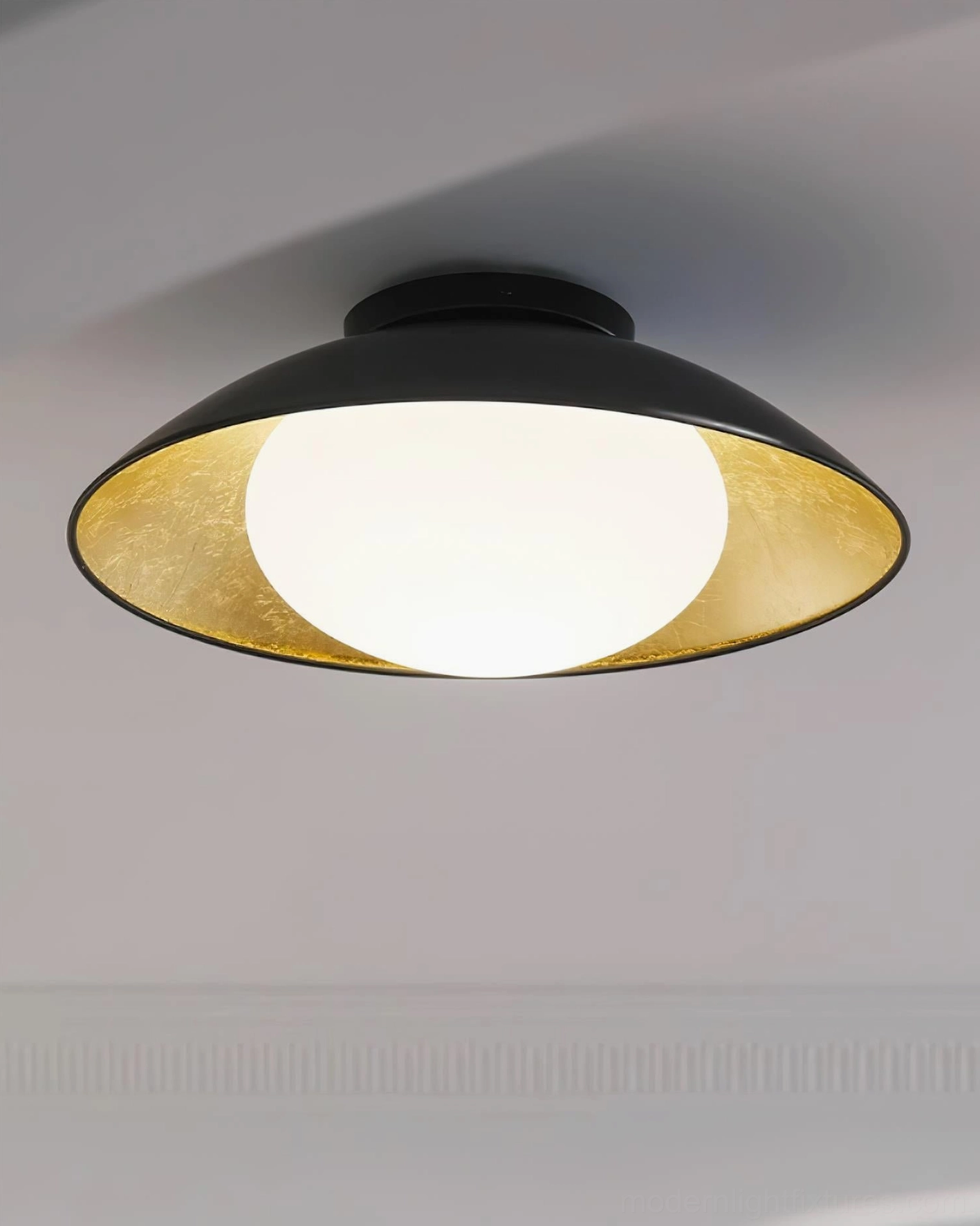 Close-up studio view of Mezo ceiling light black dome shade with gold foil interior and frosted globe