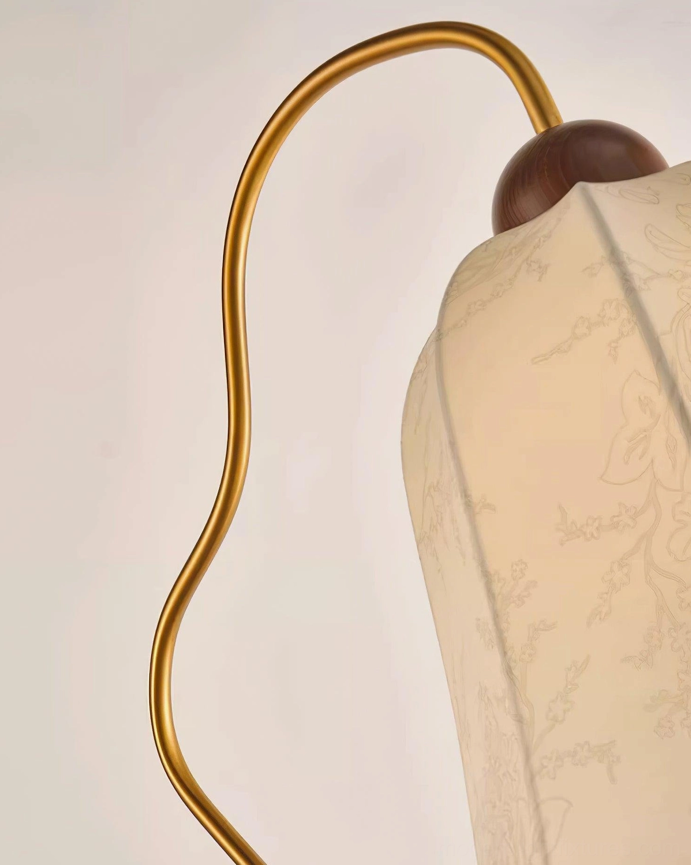 Mid-century arc floor lamp illuminating corner reading nook with warm beige shade diffusing light