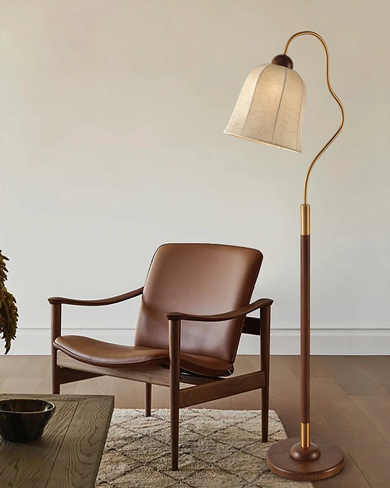 Mid-century modern arc floor lamp in reading nook with leather armchair, brass-accented walnut pole minimalist design