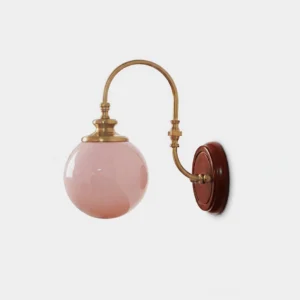 Marovin mid-century modern wall sconce with brass arm and pink opal glass globe, front studio view