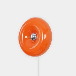 Orange mid-century modern donut wall sconce with glossy glass disc and silver metal base, front studio view
