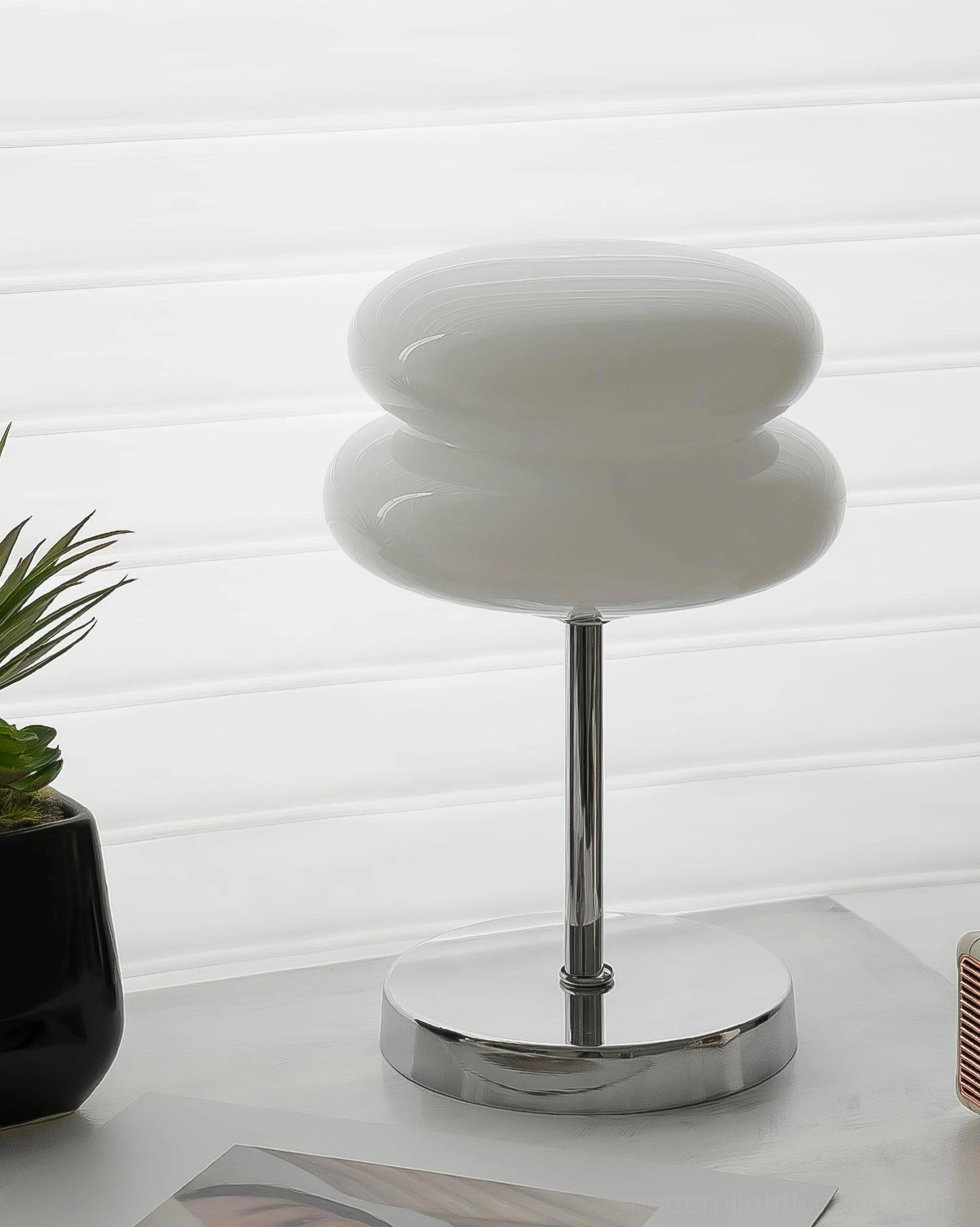 Chrome and white glass table lamp positioned on windowsill with natural light