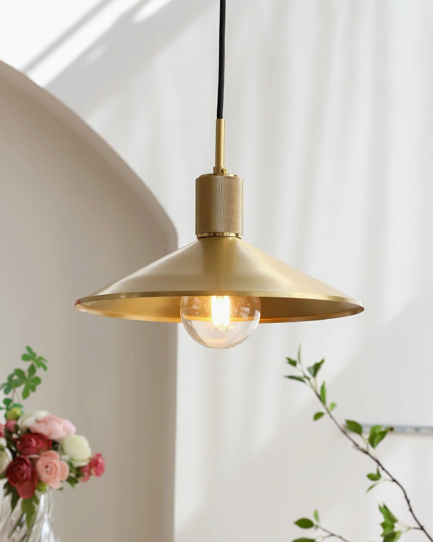 Mid-century modern brass pendant light fixture showcasing conical shade design and authentic vintage aesthetics