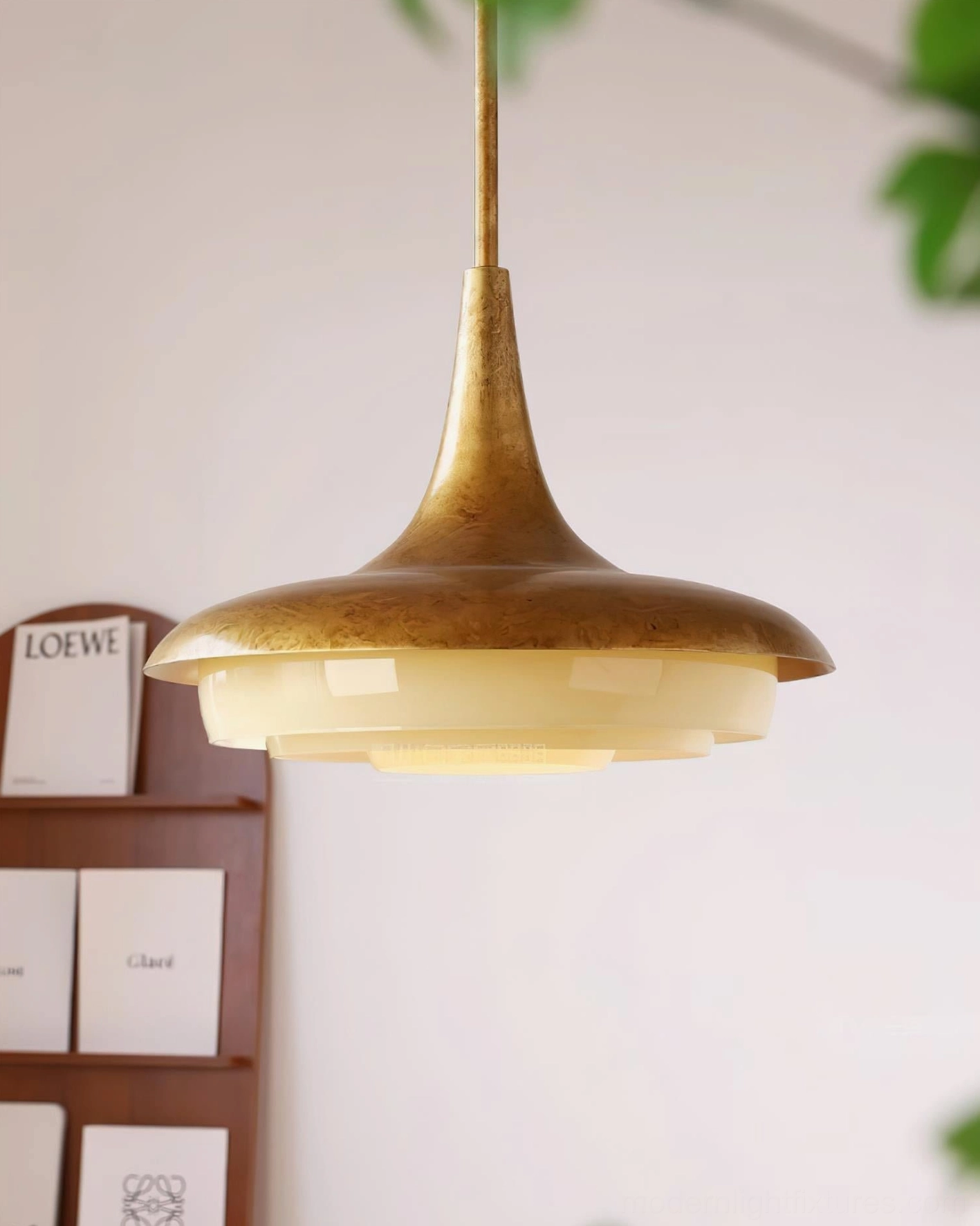 Mid-century modern brass pendant light with layered glass shade, three-quarter view with botanical styling