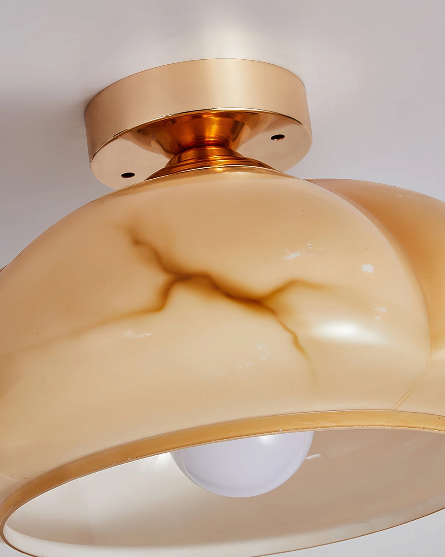 Mid-century modern ceiling light fixture with warm amber glow, brass accents, and organic pumpkin-shaped glass