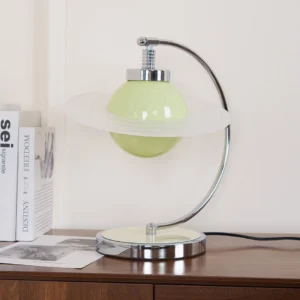 Contemporary green table lamp displayed on home interior side cabinet with decorative books and minimalist styling