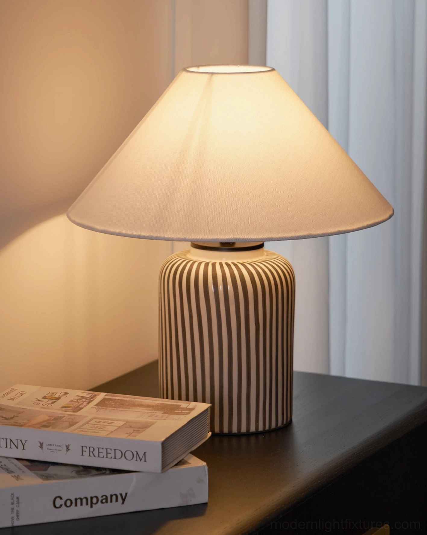 Contemporary black and white striped ceramic table lamp in mid-century modern interior setting