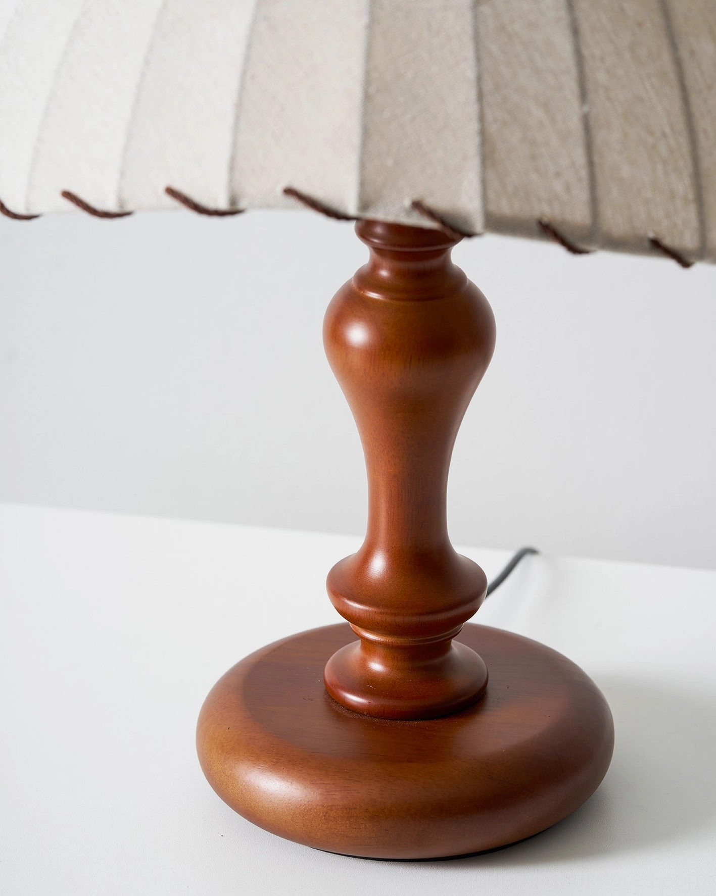 Mid-century modern style table lamp with turned wood base and vintage aesthetic appeal