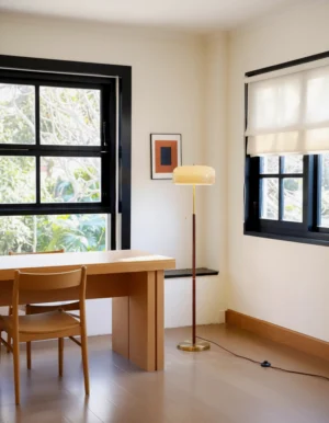 Mid-century modern mushroom floor lamp in home office setting with wooden desk and black window frame