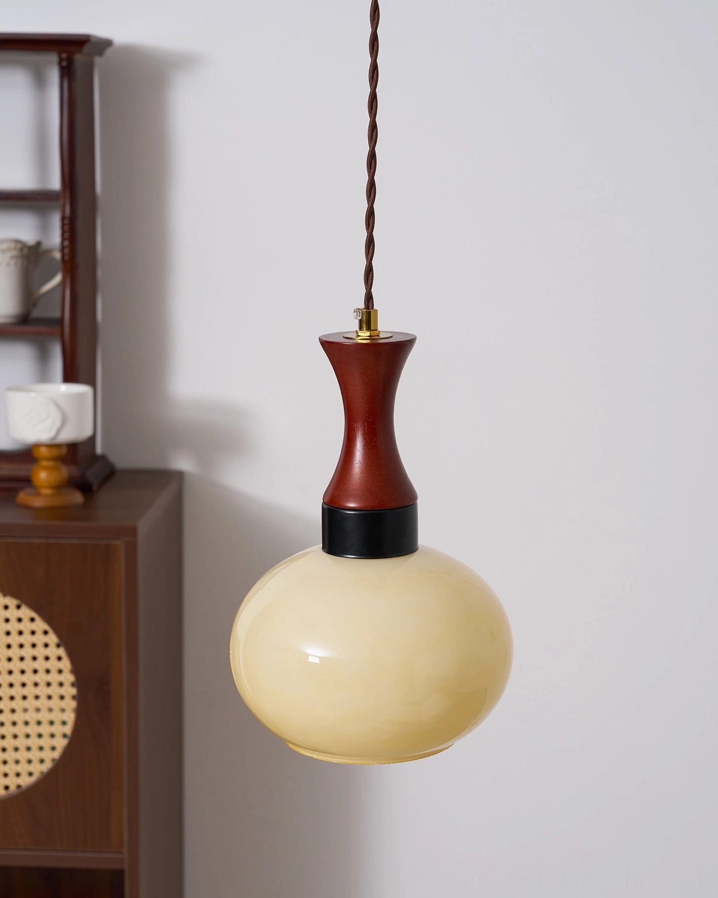 Mid-century modern hanging pendant fixture showcasing warm amber glass design