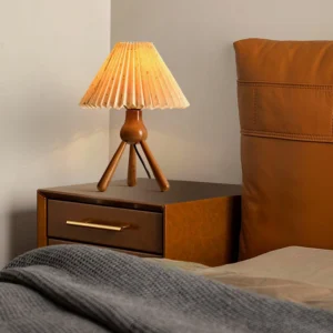 Pleated table lamp positioned on bedroom nightstand with warm ambient lighting, mid-century modern home decor