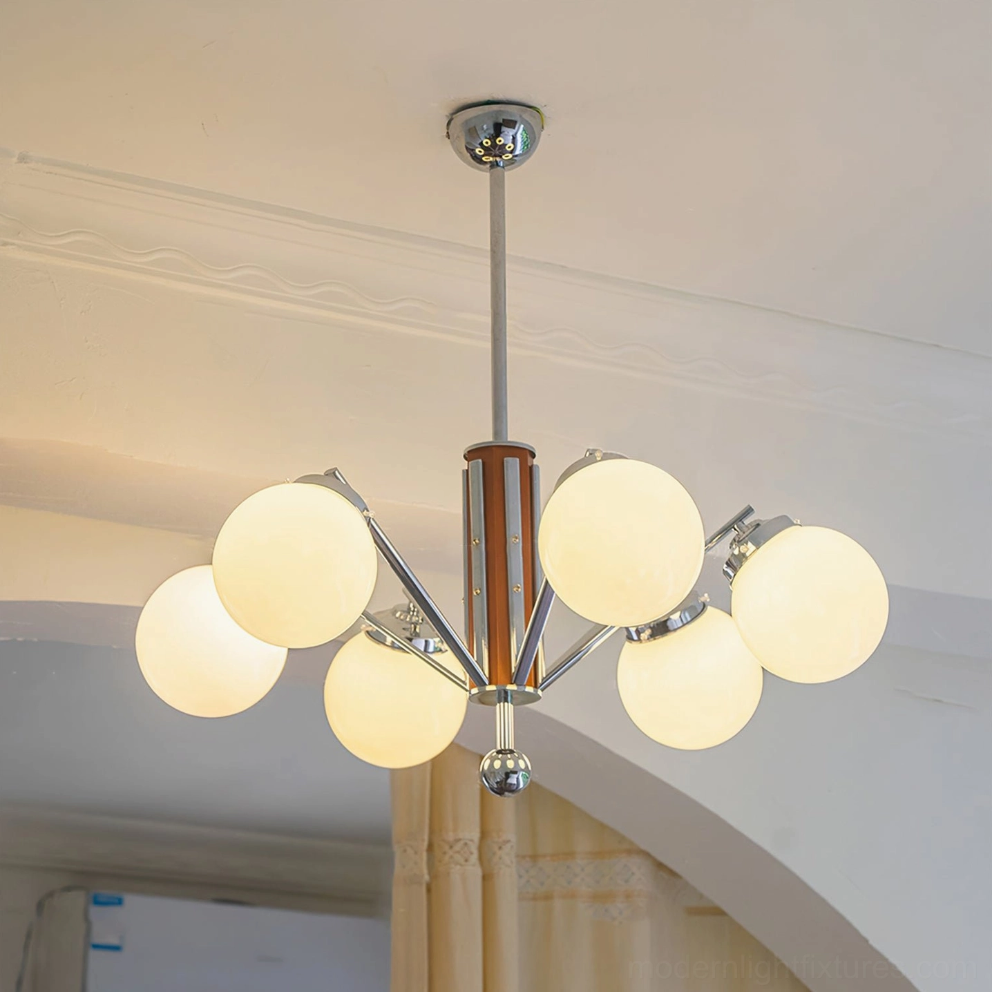 Mid-century sputnik chandelier illuminated in residential entryway, warm ambient lighting, architectural design photography