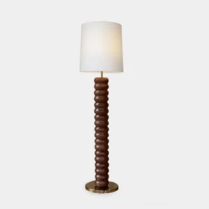 Mid-century modern stacked wood floor lamp with brass base, full frontal view on white studio backdrop