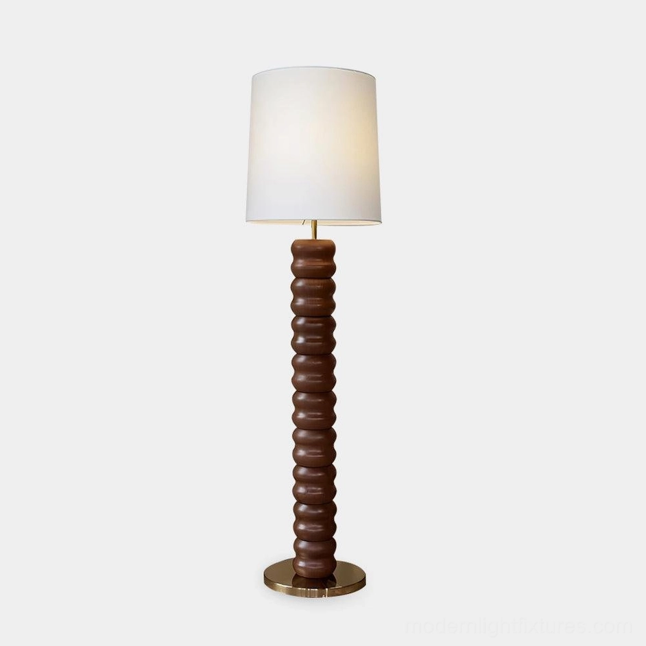 Mid-century modern stacked wood floor lamp with brass base, full frontal view on white studio backdrop
