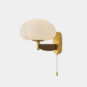 Mid-century modern wall sconce with pumpkin-shaped opal glass shade and brass metal base with walnut wood accent detail, front studio view