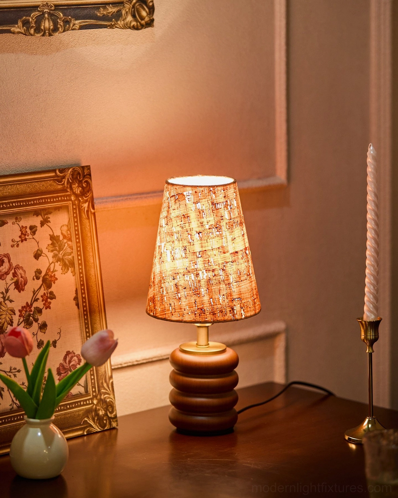 Mid-century table lamp with walnut turned base and cork shade on vintage wooden side table with art and tulips