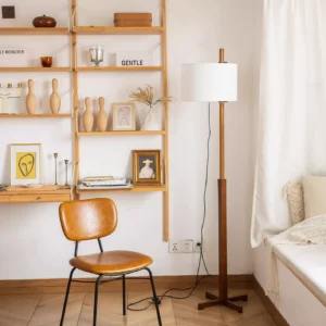 Walnut mid-century modern floor lamp in home study setting with leather chair and wall shelving, three-quarter eye-level perspective