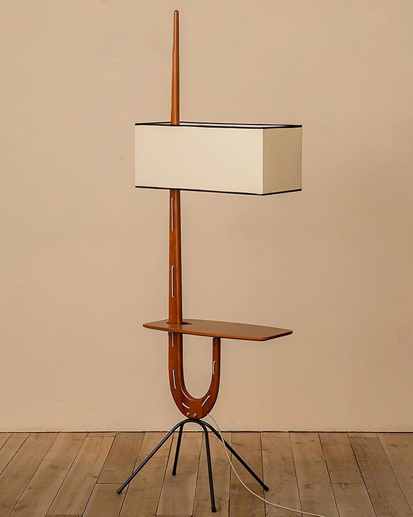 Mid-century modern wood floor lamp with tripod base clear front view in warm living room interior