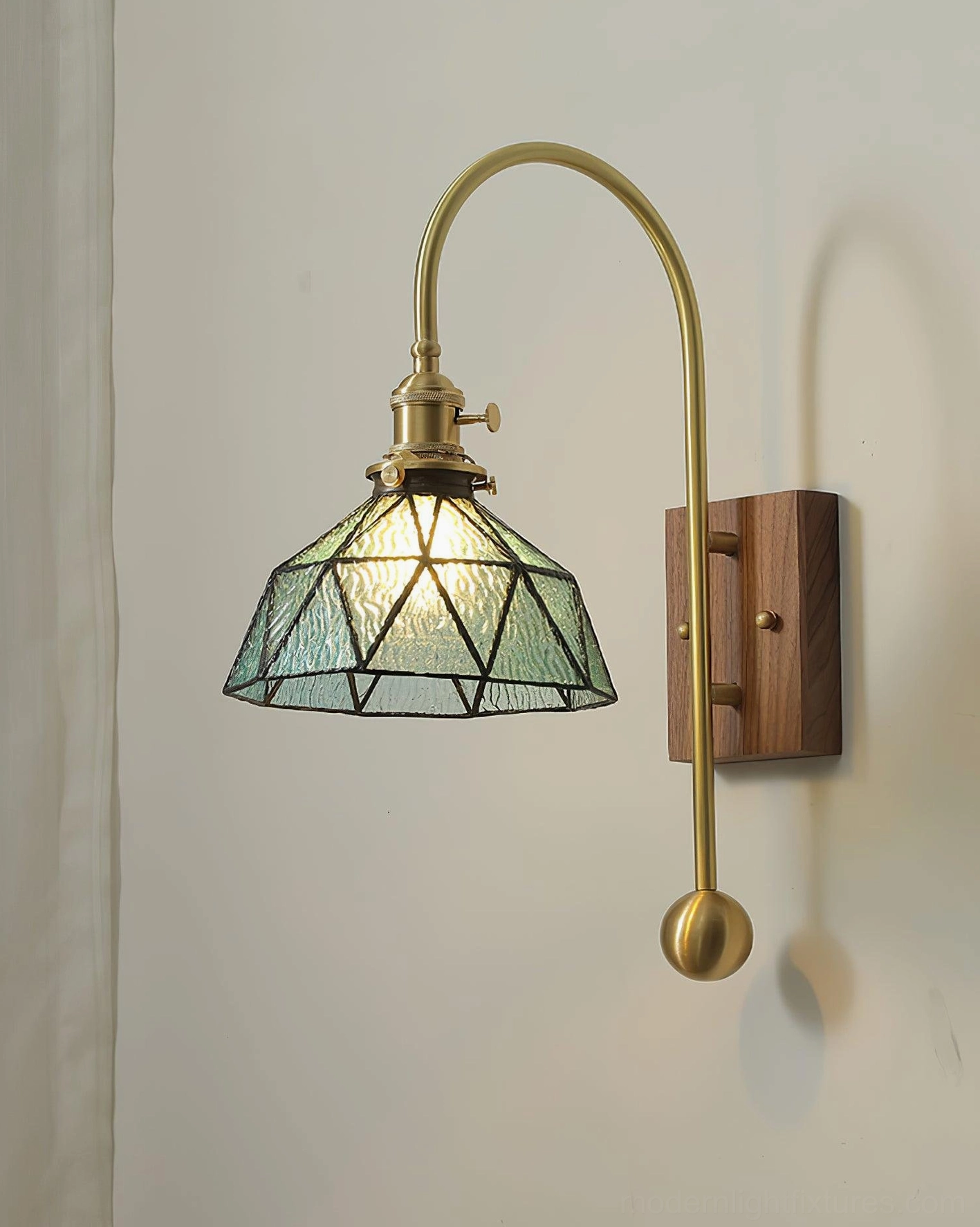 Mid-century modern wall sconce with stained glass shade and sculptural brass counterweight