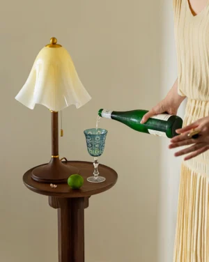 Mido ruffled glass table lamp three-quarter view on side table with decorative glassware