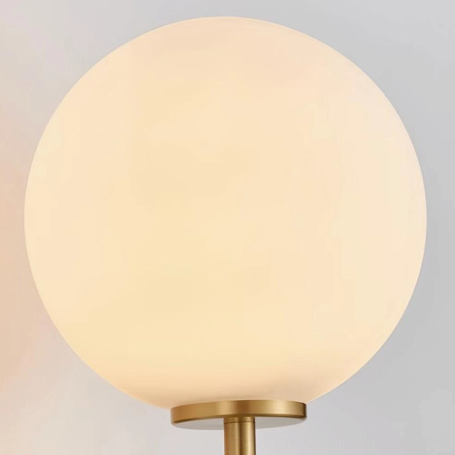 Miira wall sconce close-up detail showing mouth-blown glass texture and brass frame construction