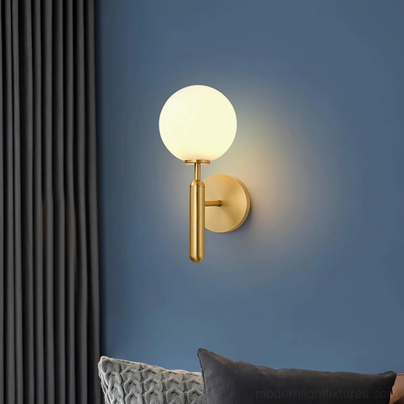 Contemporary Miira wall sconce installation showing elegant brass mounting and frosted glass sphere