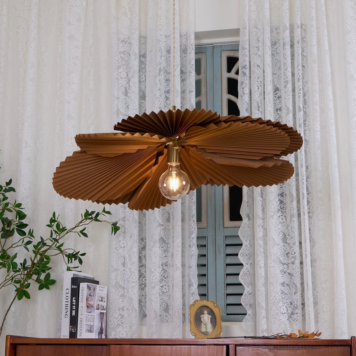 Brown kraft paper pleated pendant lamp installed in sophisticated dining area with warm ambient illumination