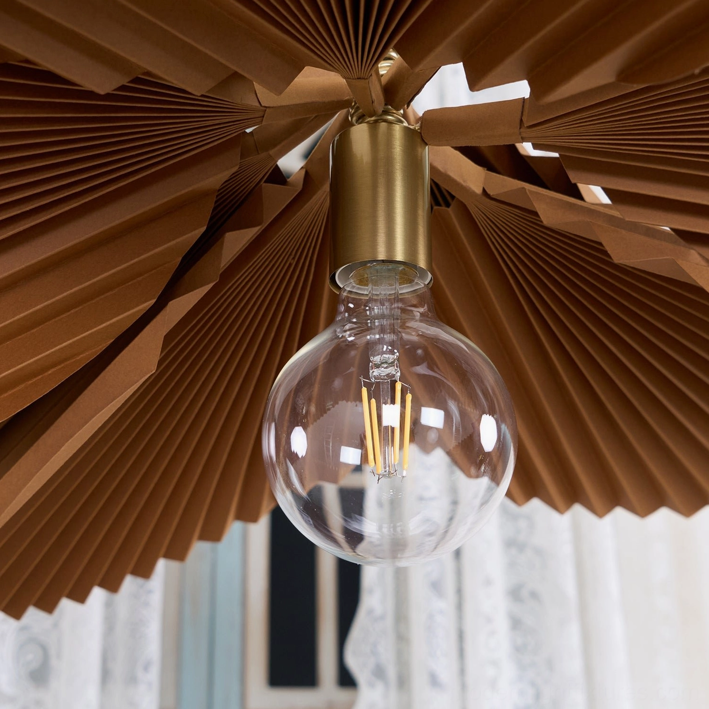 Brown pleated pendant lamp creating warm atmospheric lighting in eclectic home interior design