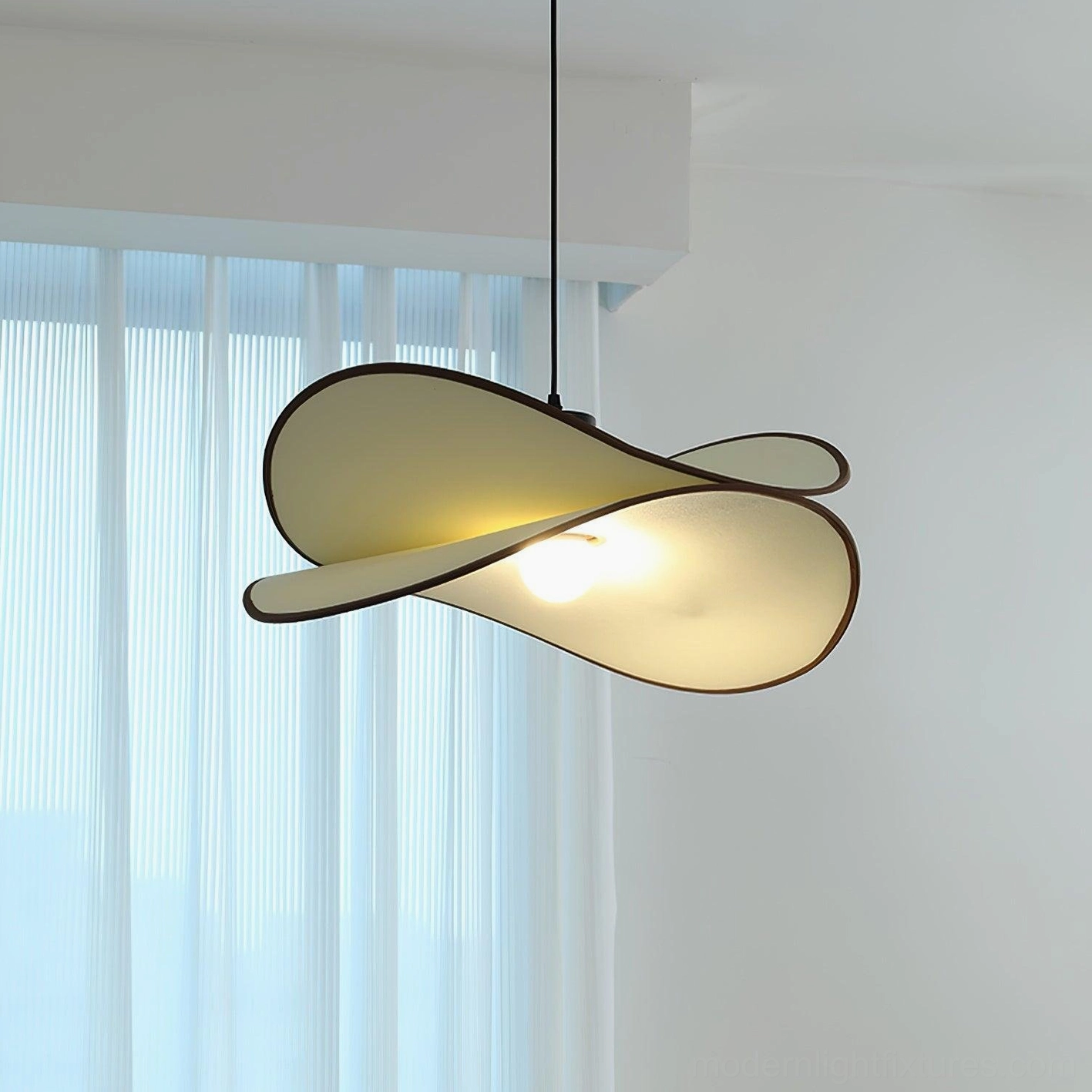 Miley organic hanging pendant lamp showing twisted petal silhouette in three-quarter side view, displayed in minimalist interior with warm ambient light glowing through white fabric shade
