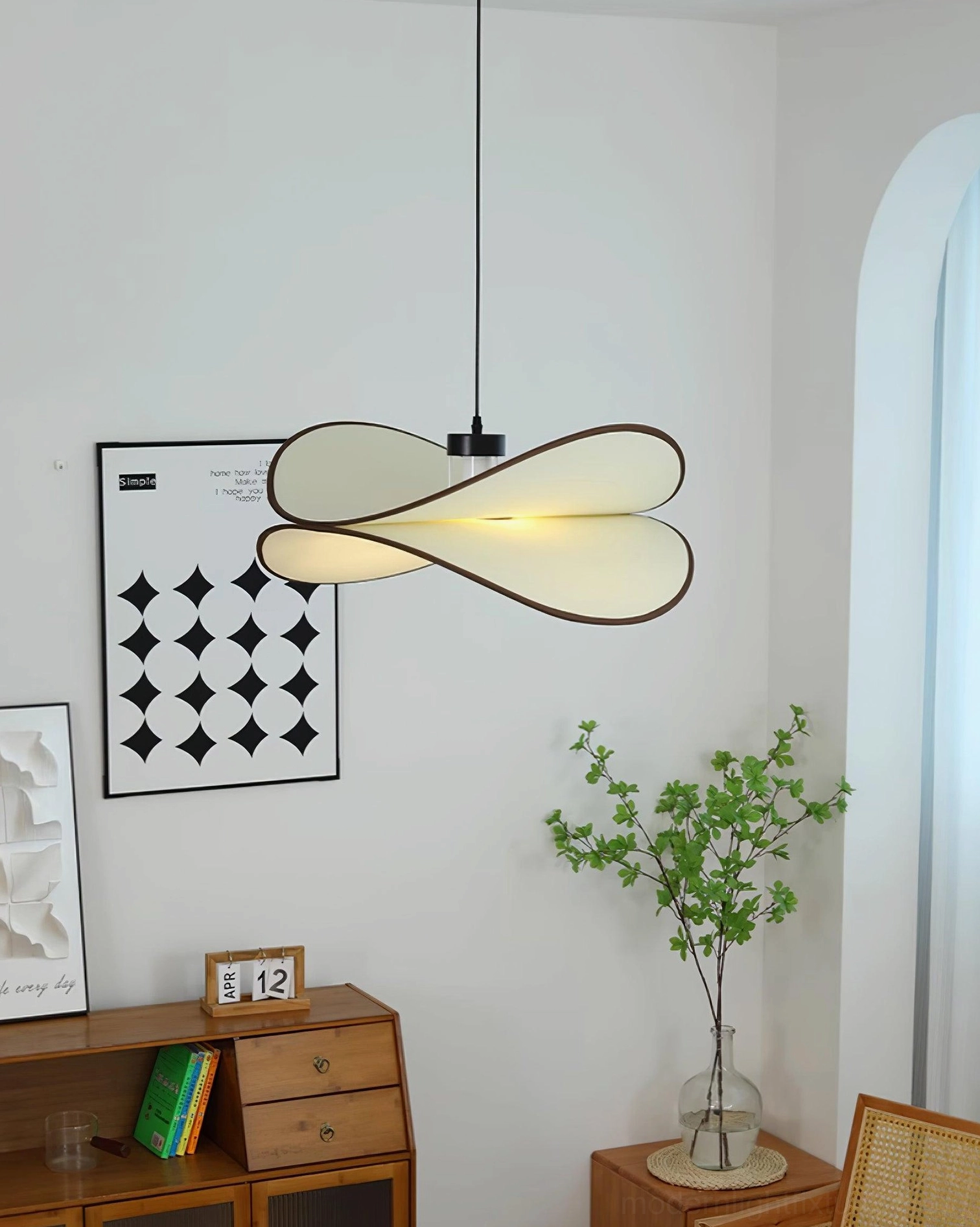 Miley double petal pendant light in front low-angle view from minimalist living space, warm neutral nordic style with wooden furniture and geometric wall decoration