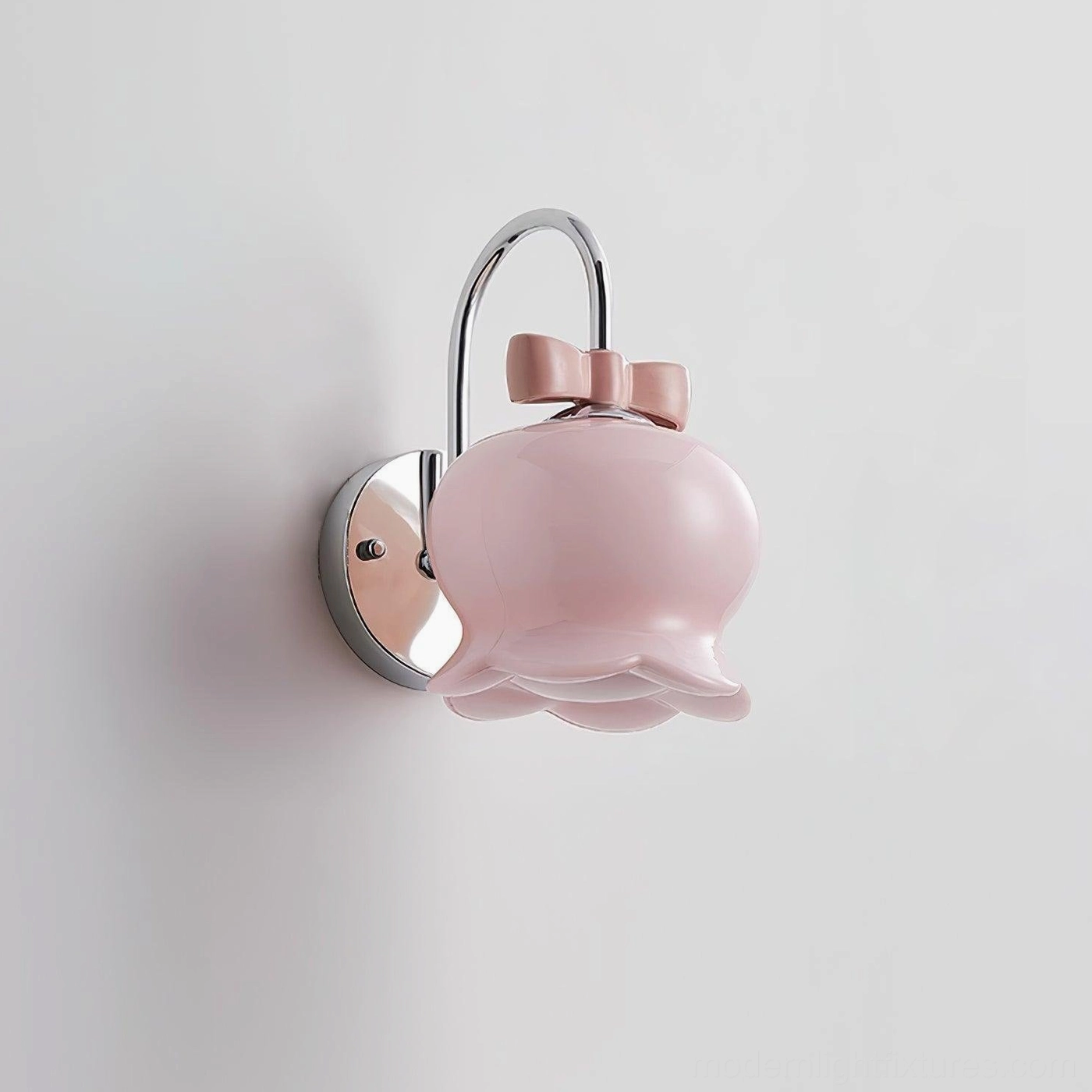 Millie Bells ceramic wall sconce with soft neutral cream shade and metal mounting hardware, featuring signature bow accent design element