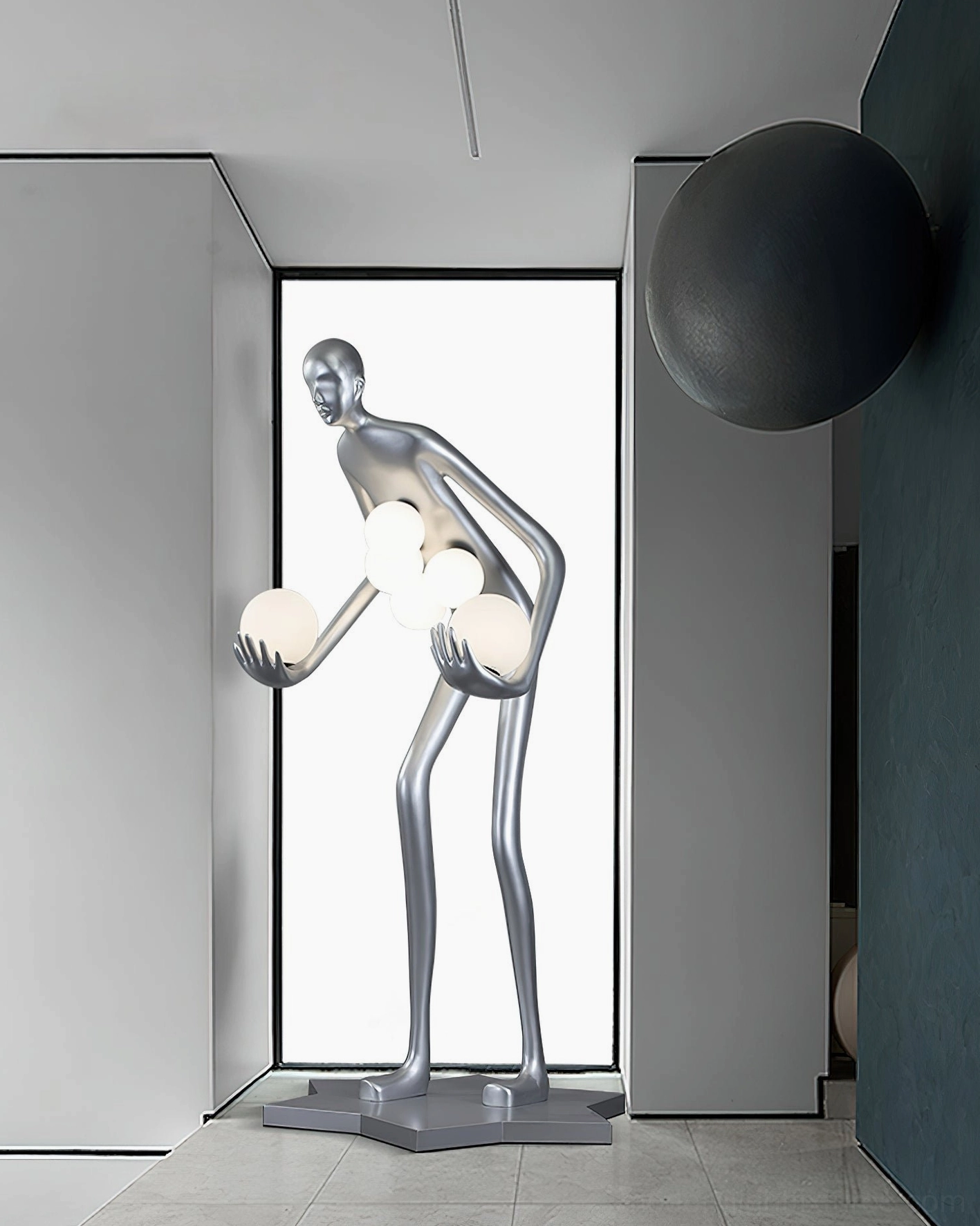 Artistic humanoid floor lamp with frosted glass orbs, silver finish, positioned in modern entryway with teal accent wall