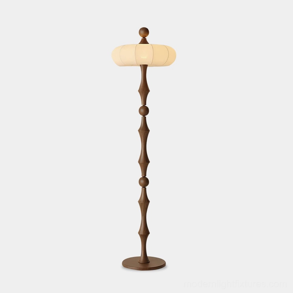 Milo mid-century modern floor lamp with walnut wood carved pole and off-white fabric lantern shade, front direct view against studio background