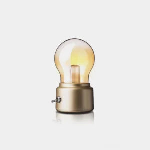 Champagne gold miniature Edison bulb table lamp with clear glass shade displayed against neutral background