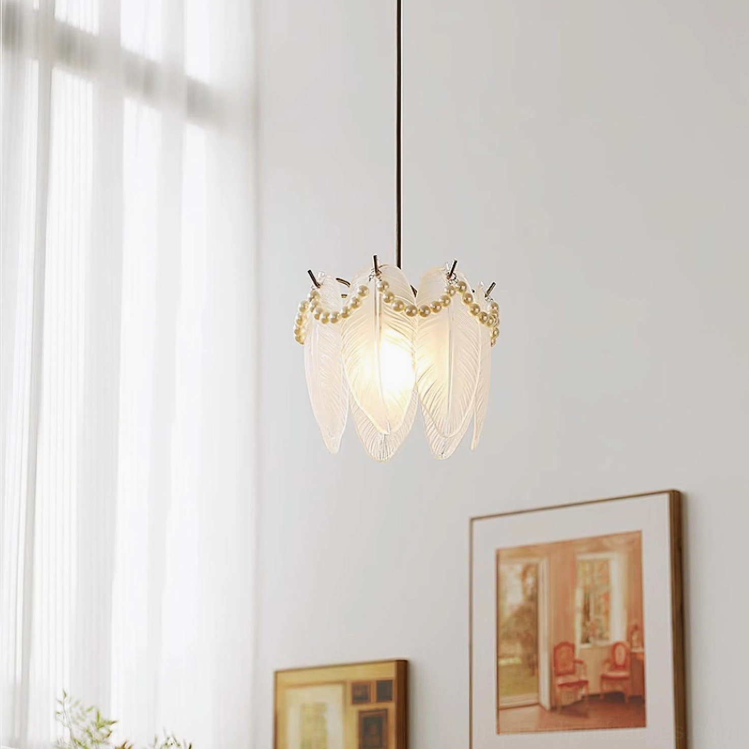 Mini crystal feather petal pendant lamp with pearl trim hanging in living room with framed wall art and ambient glow