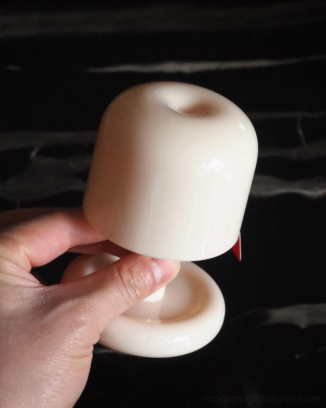 Close-up detail of Mini Mushroom Lamp held by fingertips - Smooth glossy finish