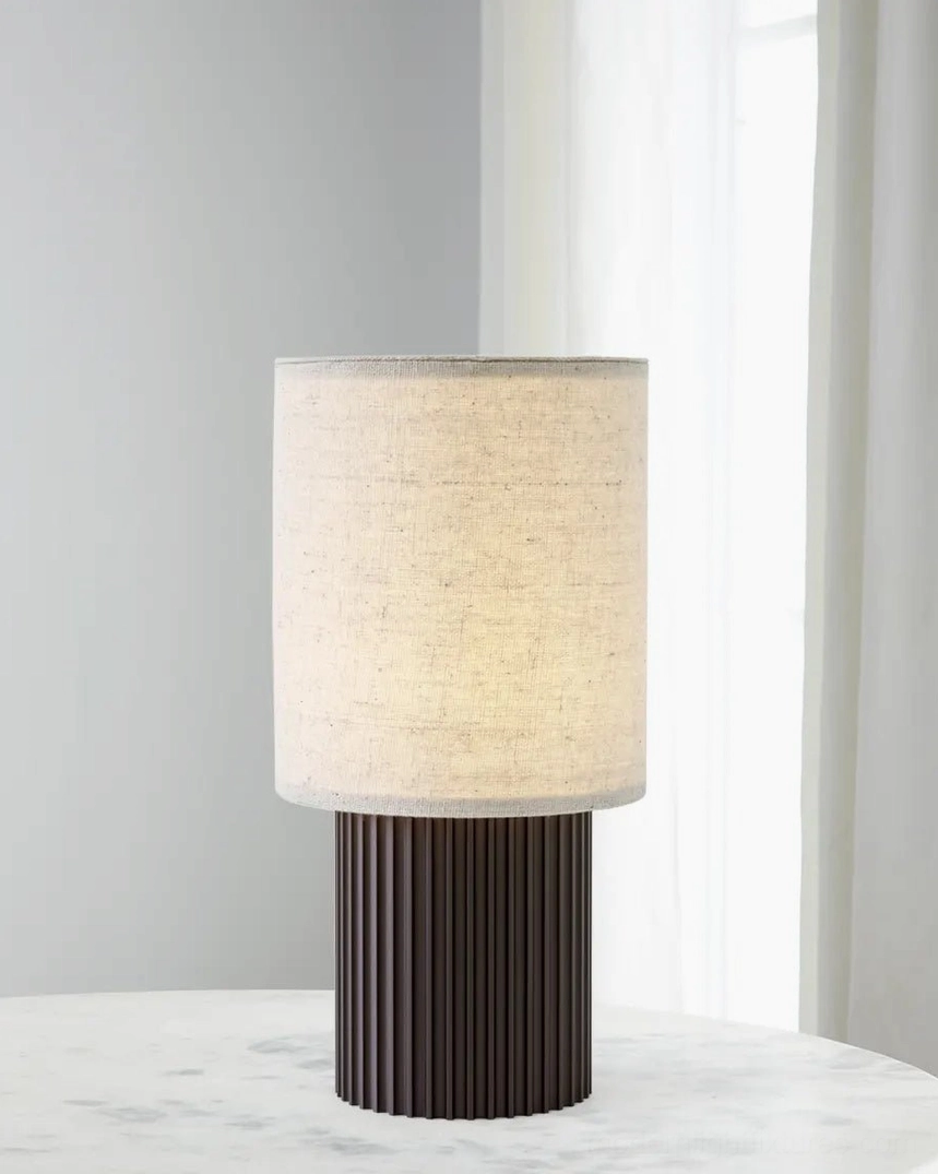 Modern wireless charging table lamp creating warm ambient 3000K lighting in minimalist bedroom sanctuary, promoting sleep quality and relaxation