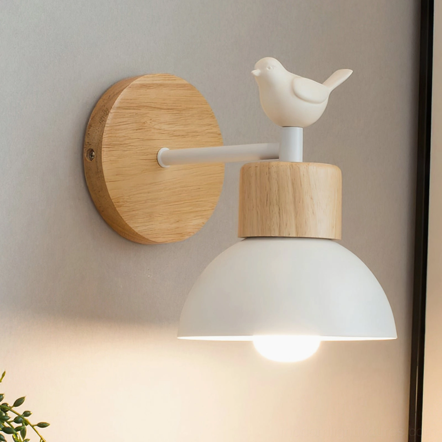 Minimalist bird wall sconce front view with lit bulb, solid wood base, and resin bird ornament