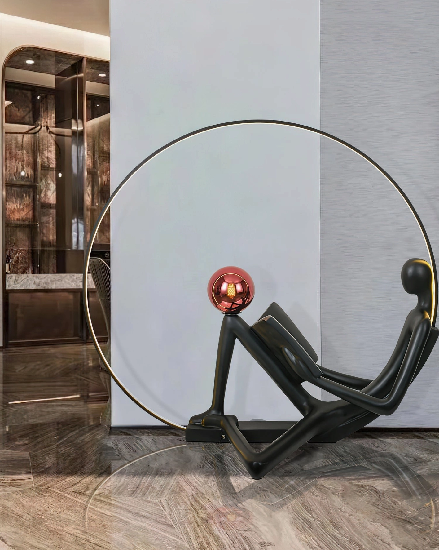 Modern minimalist reading figure floor lamp with golden metal hoop frame, black resin sculptural design
