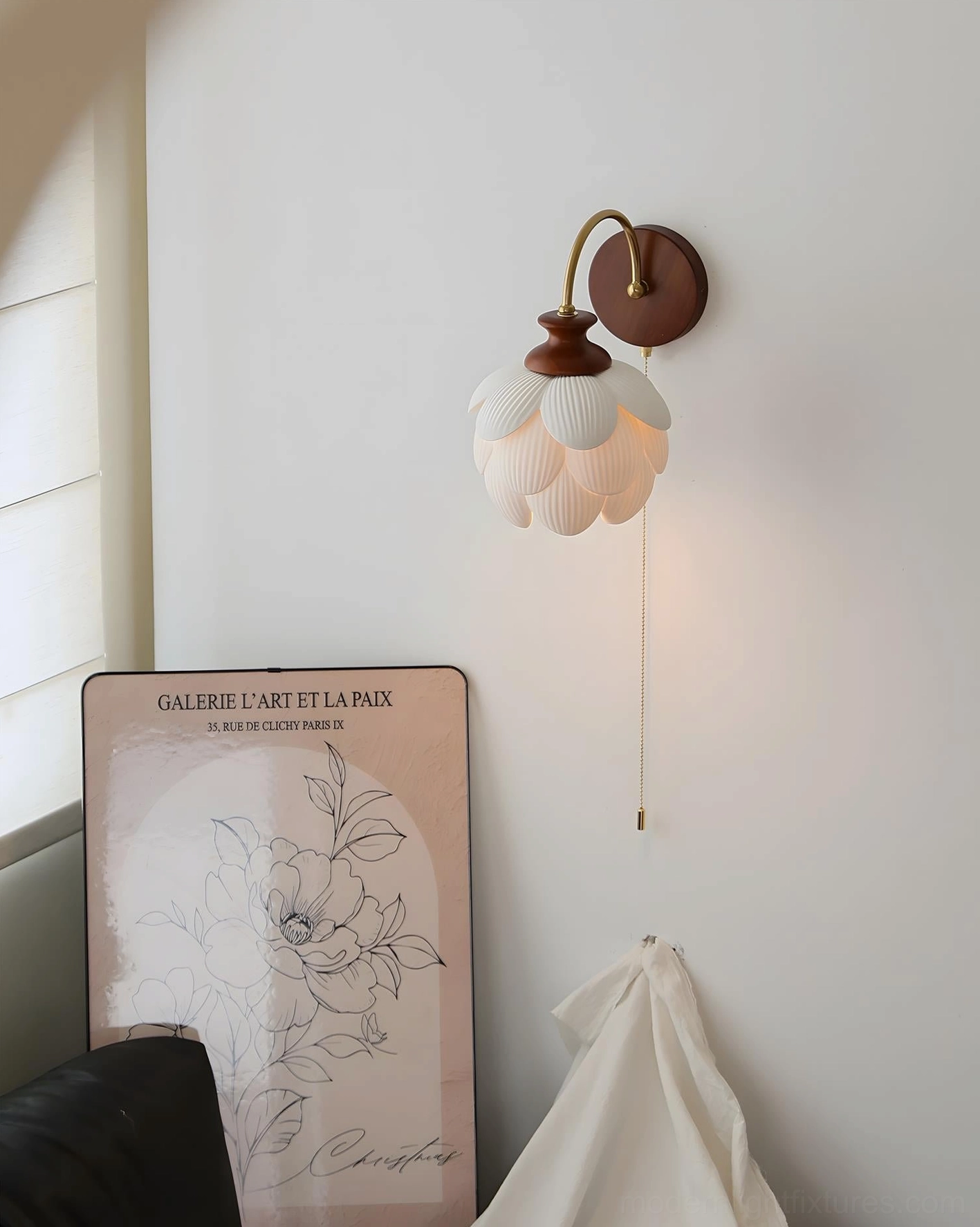 Unlit porcelain petal wall lamp showing ceramic hand-shaped design and pull-chain control in minimalist studio setting