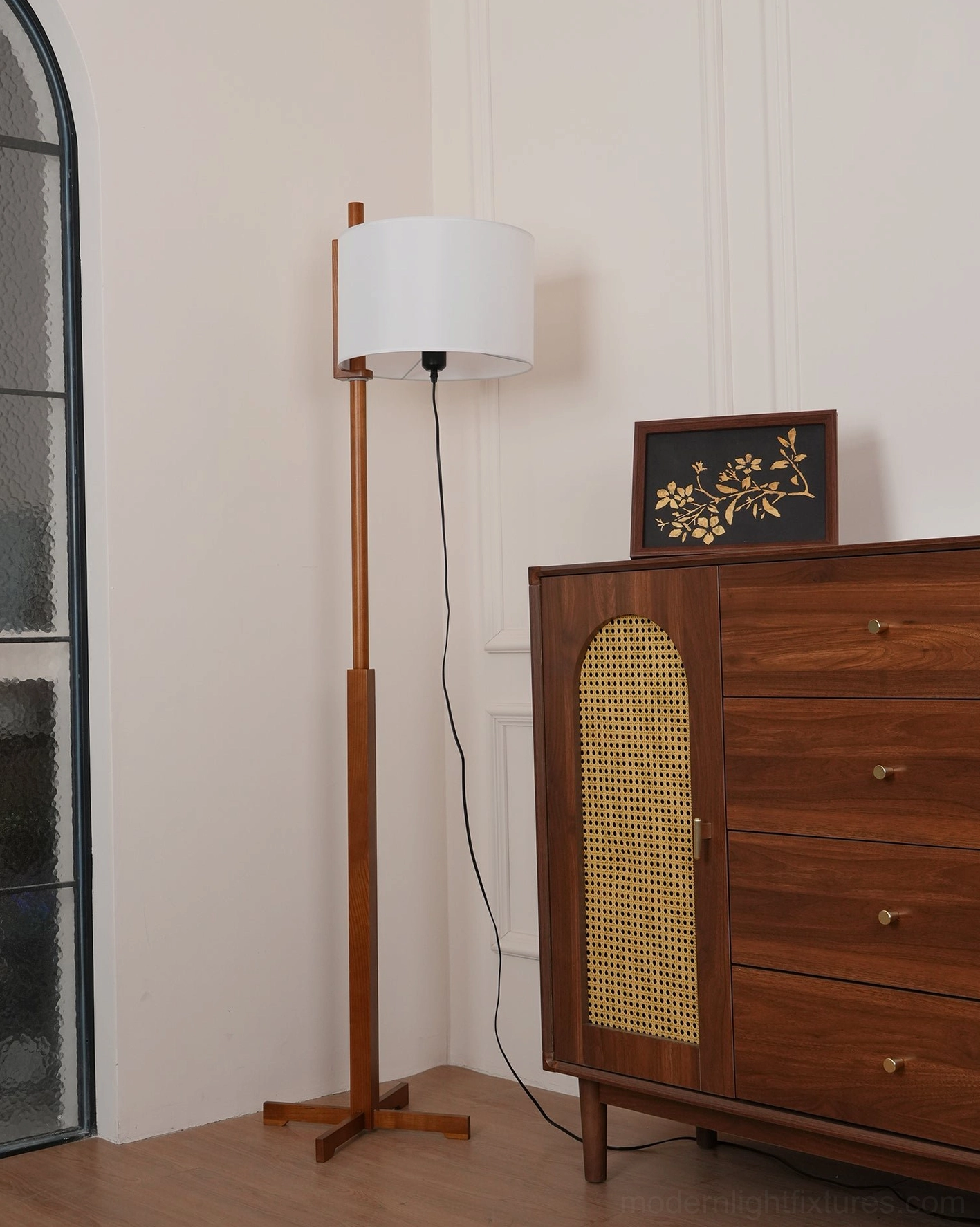 Minimalist walnut floor lamp with white shade positioned in bright residential living space, showing spatial relationship