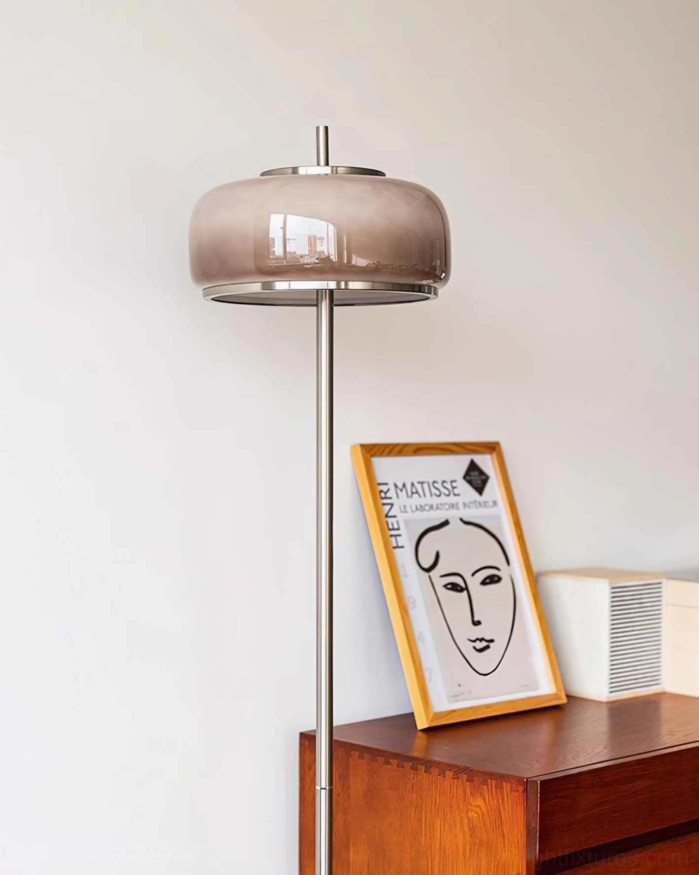 Minimalist mushroom floor lamp with taupe frosted glass dome chrome metal stem on wooden side table with art print