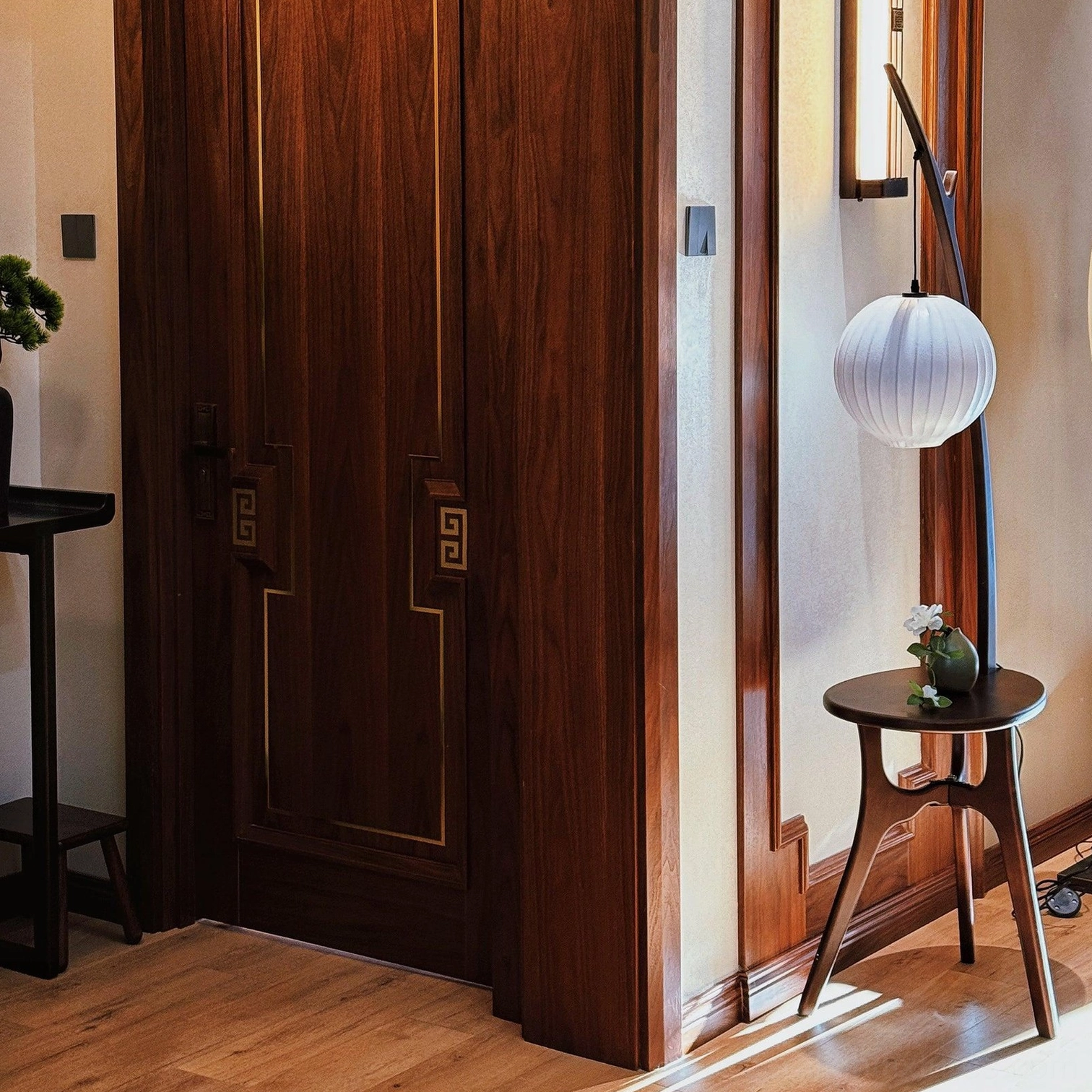 Modern wooden floor lamp with side table and white spherical fabric shade in minimalist hallway