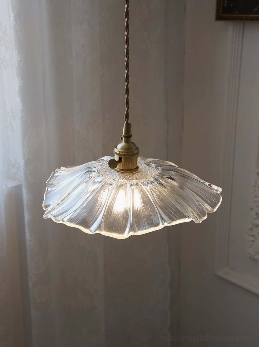 Minimalist glass flower pendant light with clear petal shade and refined brass base