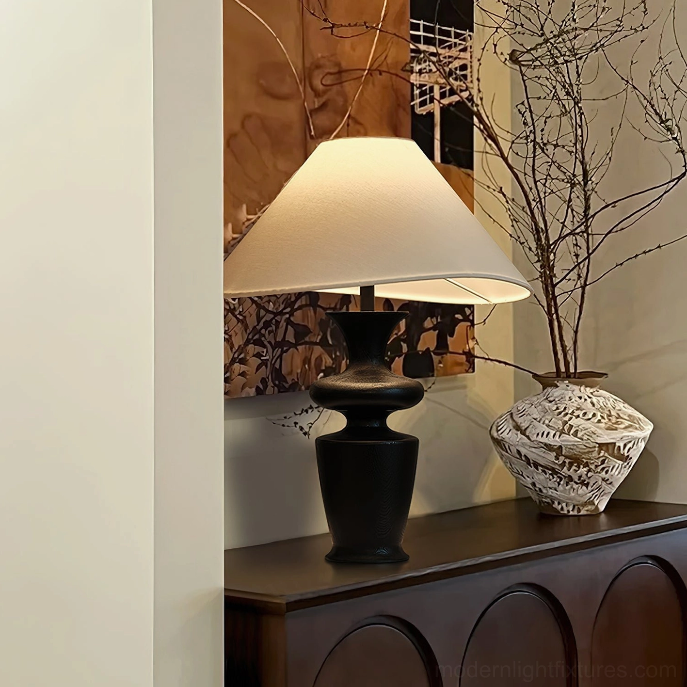 Modern minimalist table lamp on carved wooden sideboard with dried floral vase and wall art, eye-level interior design scene