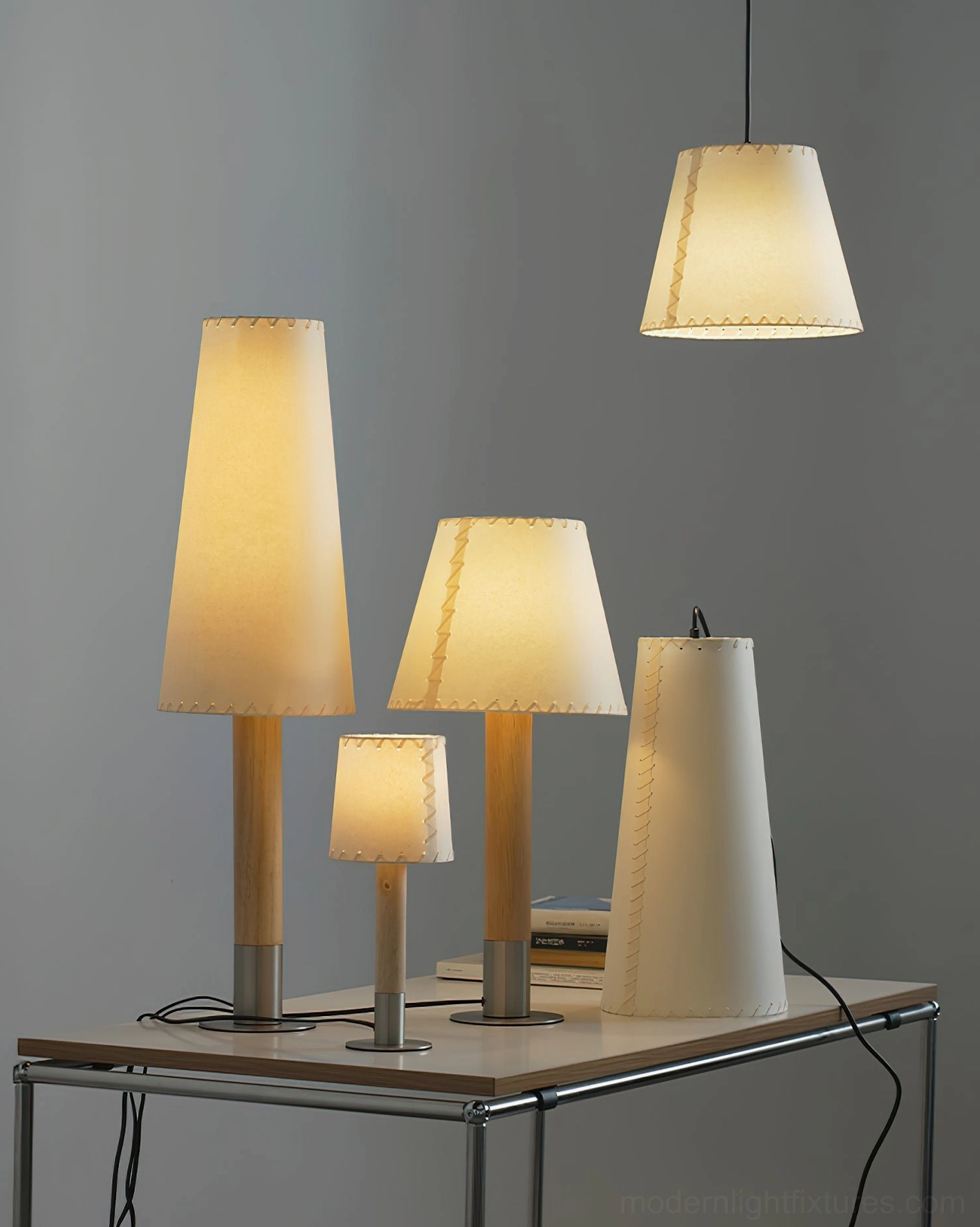 Modern minimalist lighting fixtures collection - table lamps and pendant lights on metal display table