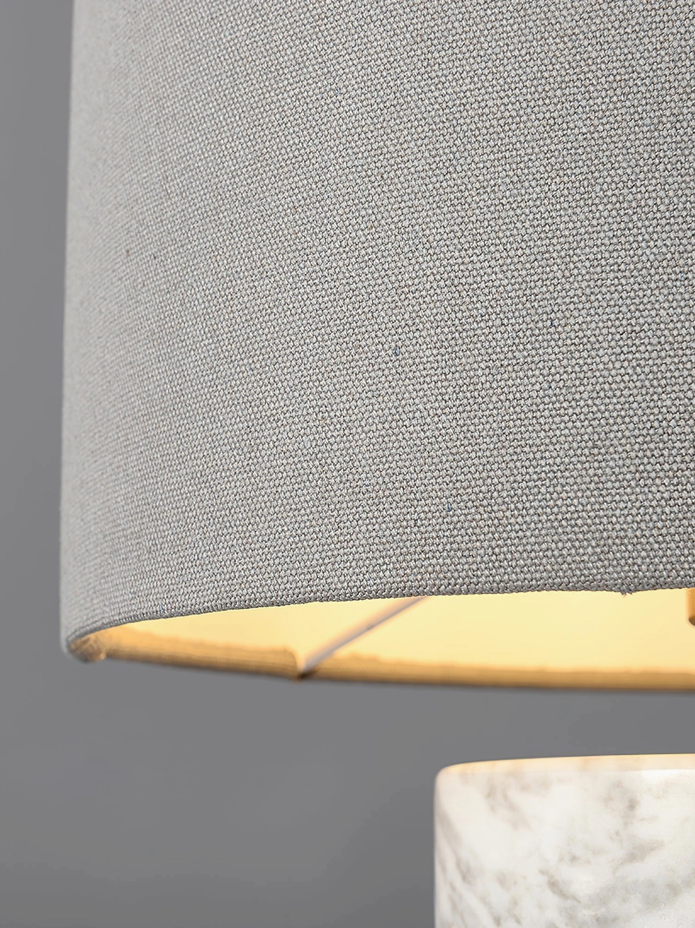 Minimalist marble table lamp with black fabric shade and cylindrical natural stone base against neutral background